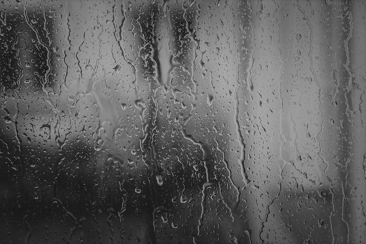 Rainy view through glass window in black and white