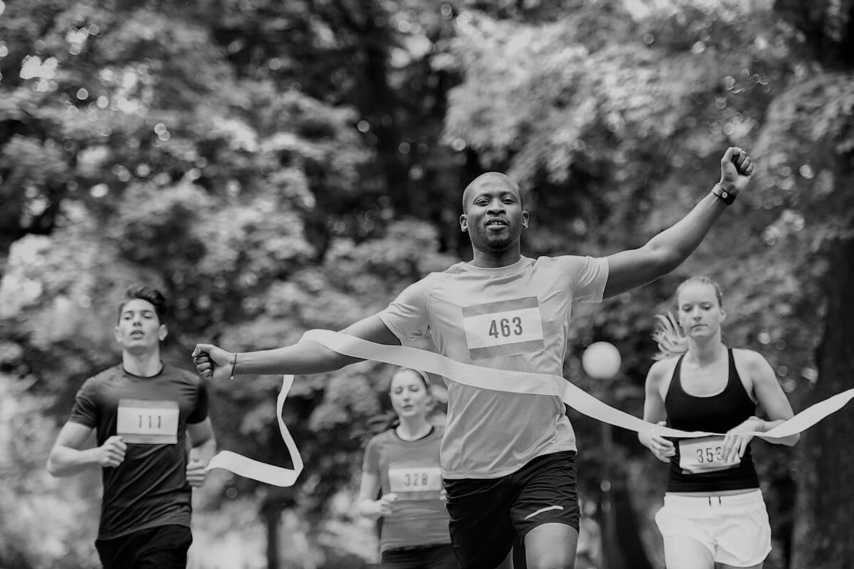 Four People Racing in Marathon, crossing finishing line