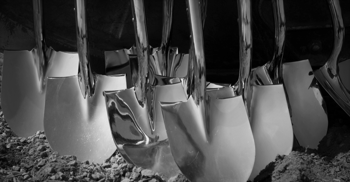 Multiple shovels leaning against each other, ready for groundbreaking ceremony