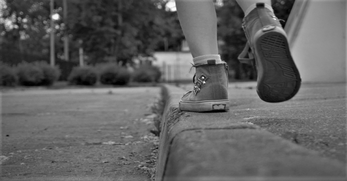 Kid walking on sidewalk in black and white