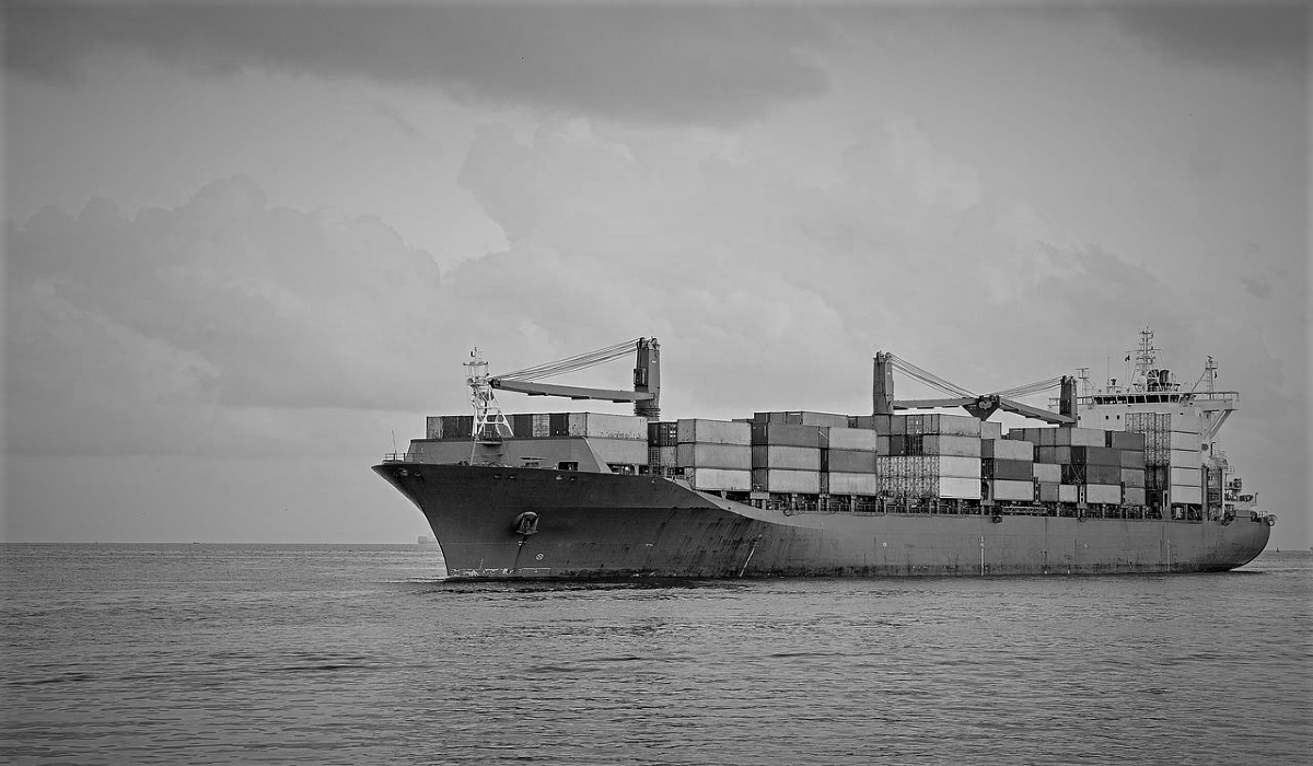 Wide shot of a cargo ship at sea, friend shoring