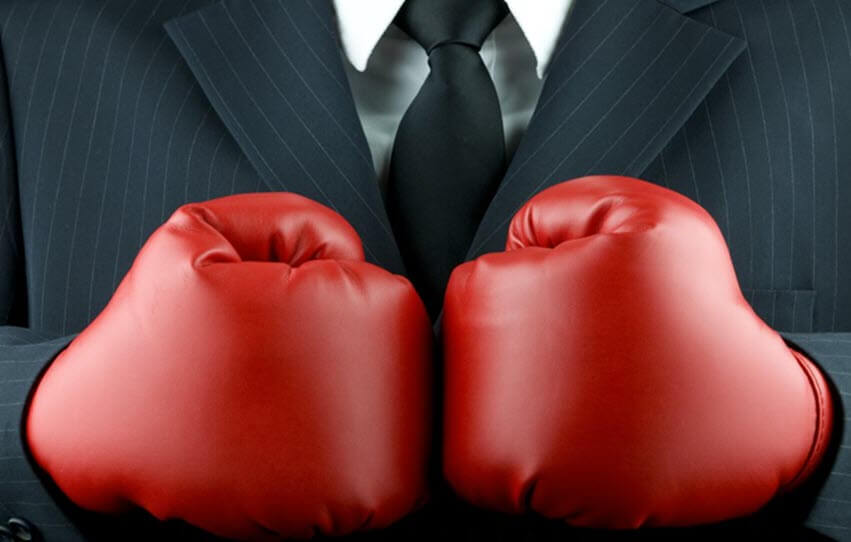 Close up of person wearing a black and white suit with red boxing gloves