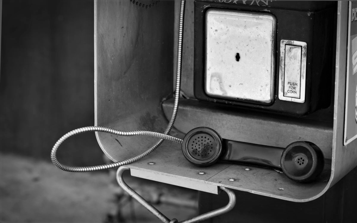 Payphone left hanging in black and white