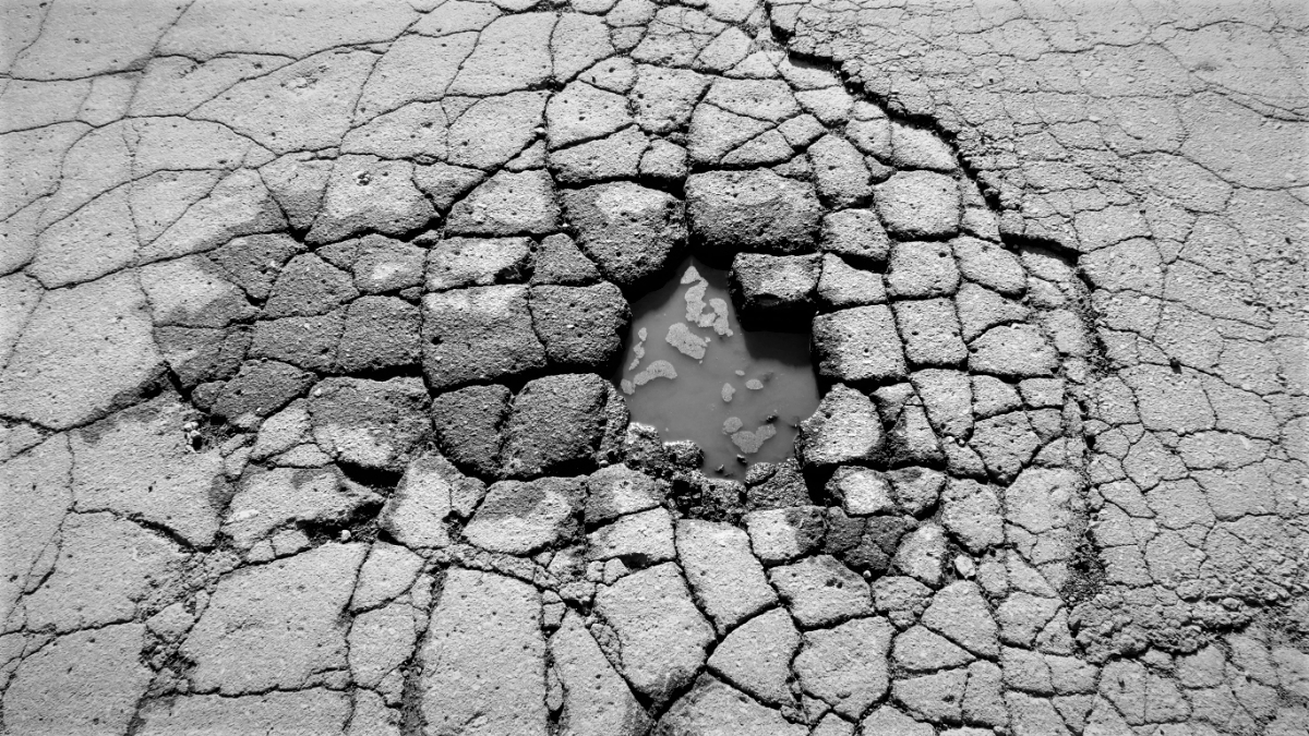 Pothole in street with radiating cracks