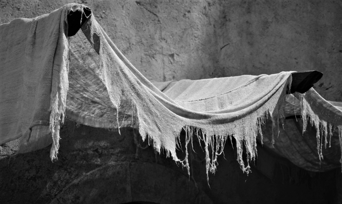 Torn and frayed cloth hanging from wooden beams