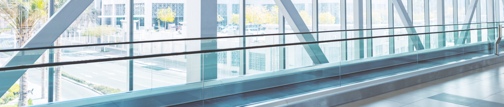 Hallway with moving walkway and floor-to-ceiling windows: Get started with an Intelligize Trial