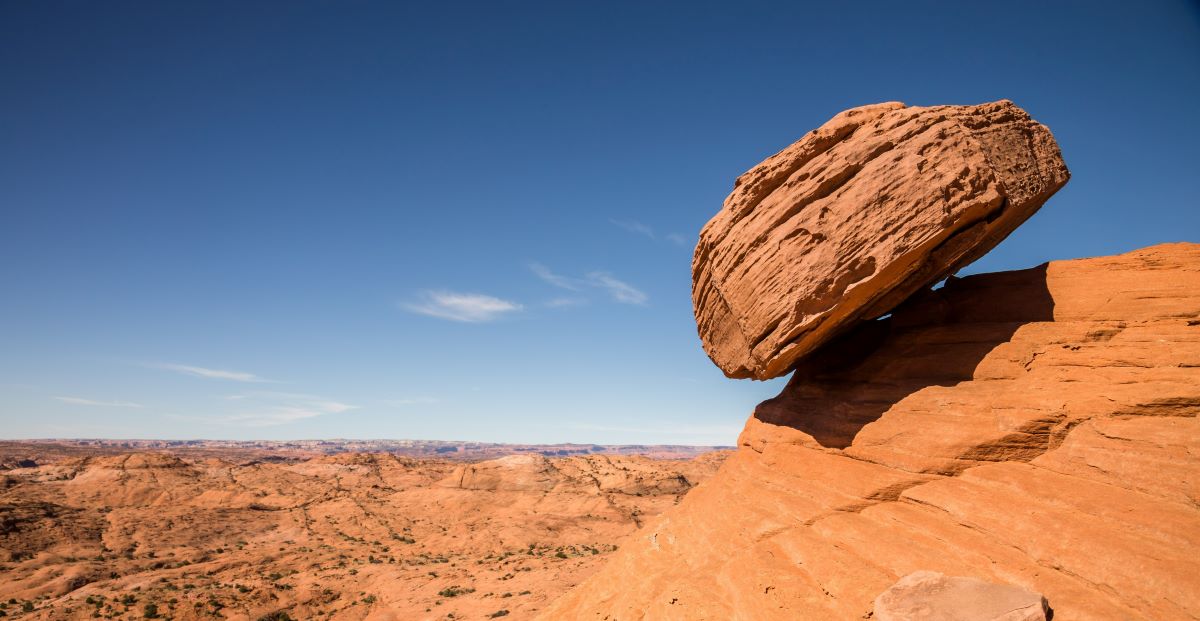 Large boulder rests precariously atop the edge of a cliff