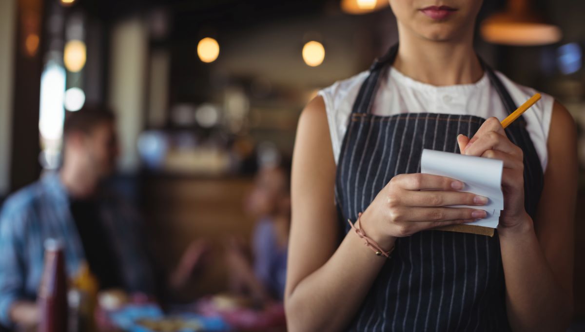 restaurant server with a pencil and pad of paper