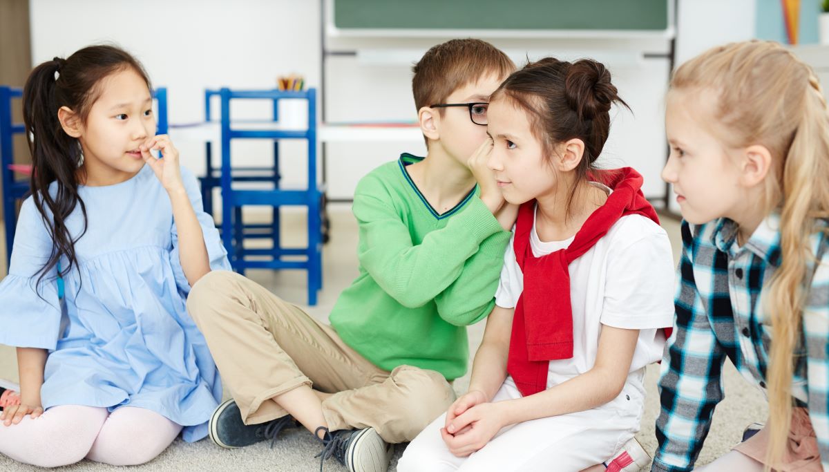 Four kindergarteners whispering gossip