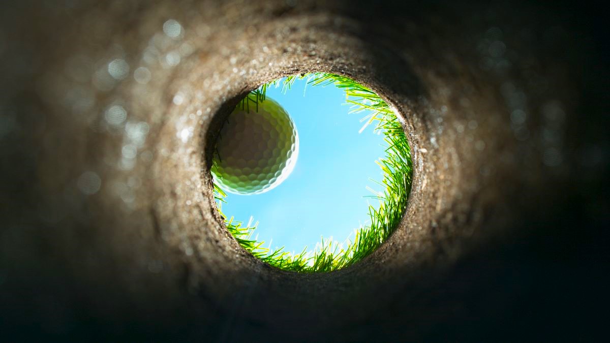 View from inside a golf hole, ball is about to fall in