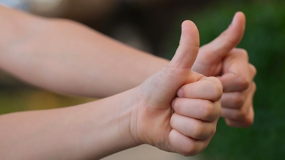 Two arms making thumbs-up signals