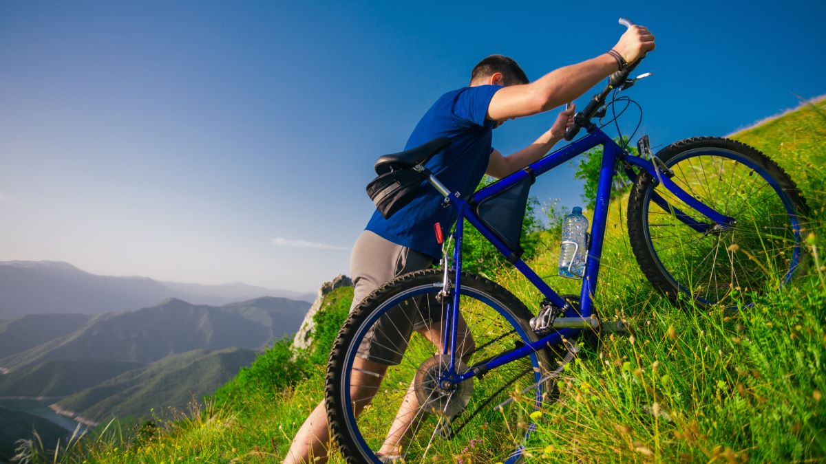 Man pushing bike up a steep hill