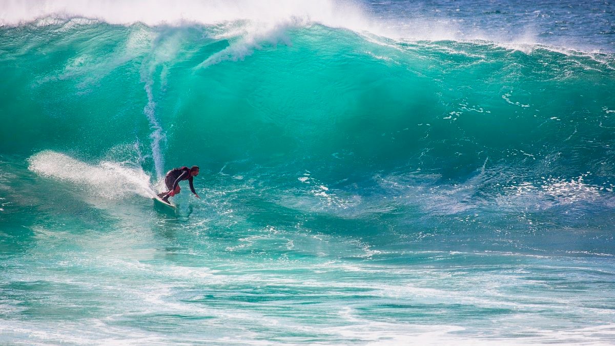 Person surfing on large wave