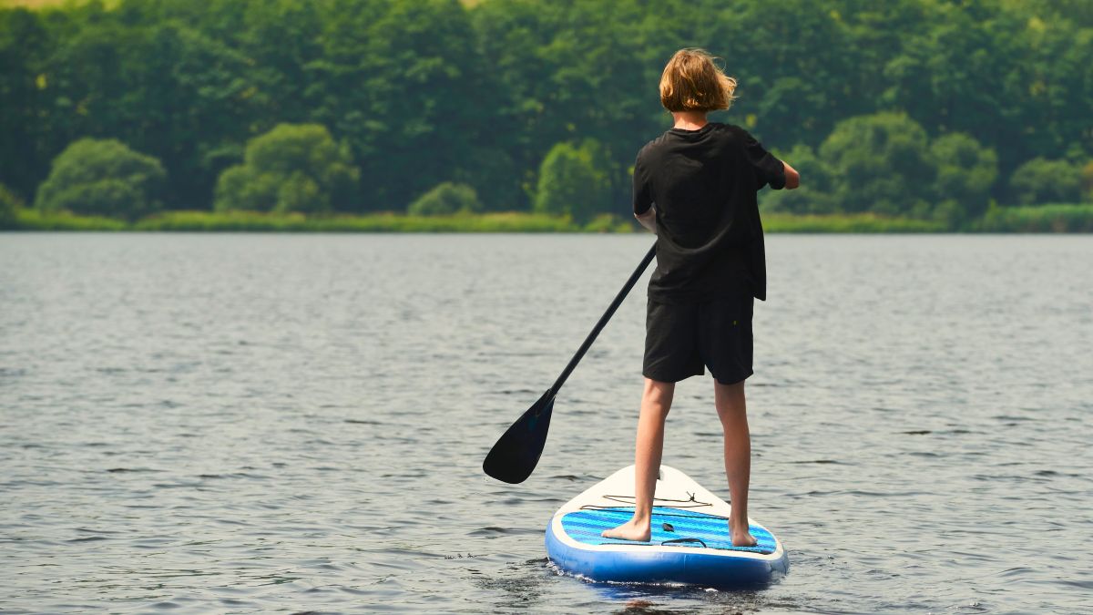 boy standing on paddleboard